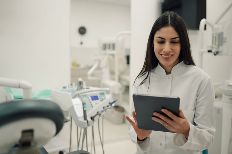 Dentista utilizando tablet digital en clínica moderna