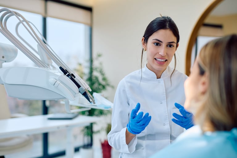 Dentista joven consultando sobre salud oral con paciente
