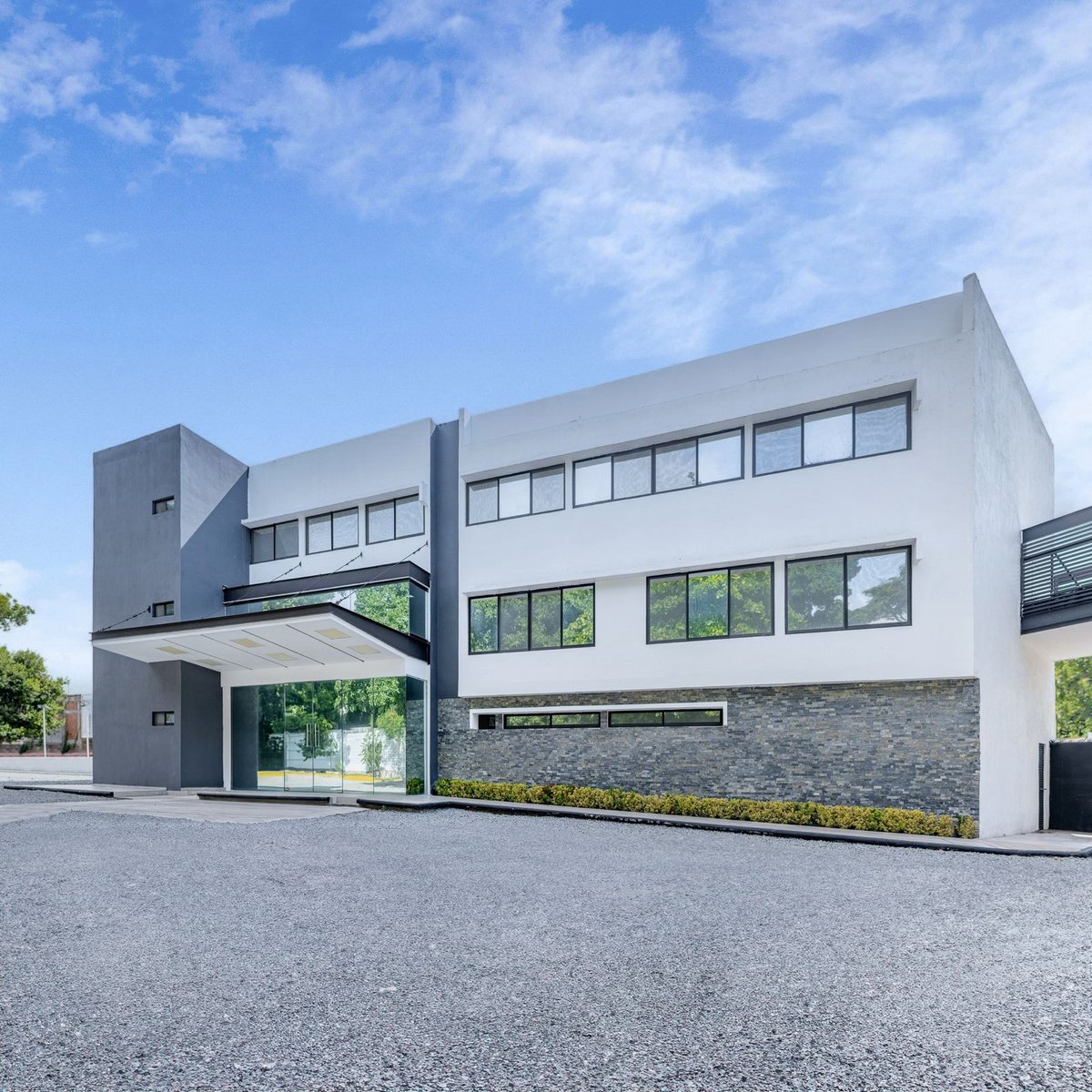 Casa residencial moderna con diseño minimalista, ventanas grandes y paisajismo