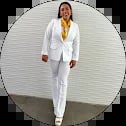 Woman in white blazer and pants standing against circular white brick wall background